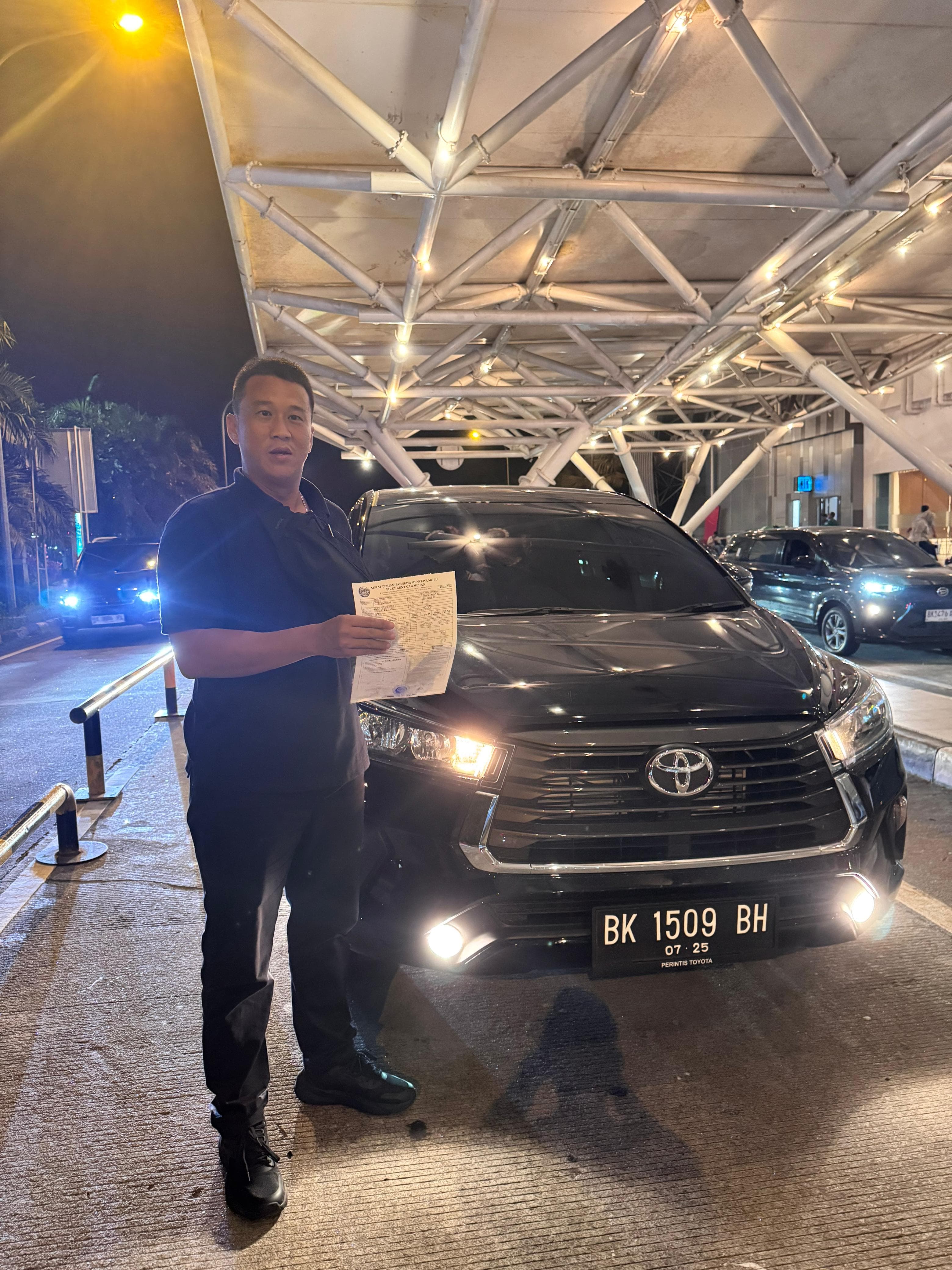 Pelanggan sedang memasukkan koper ke bagasi mobil