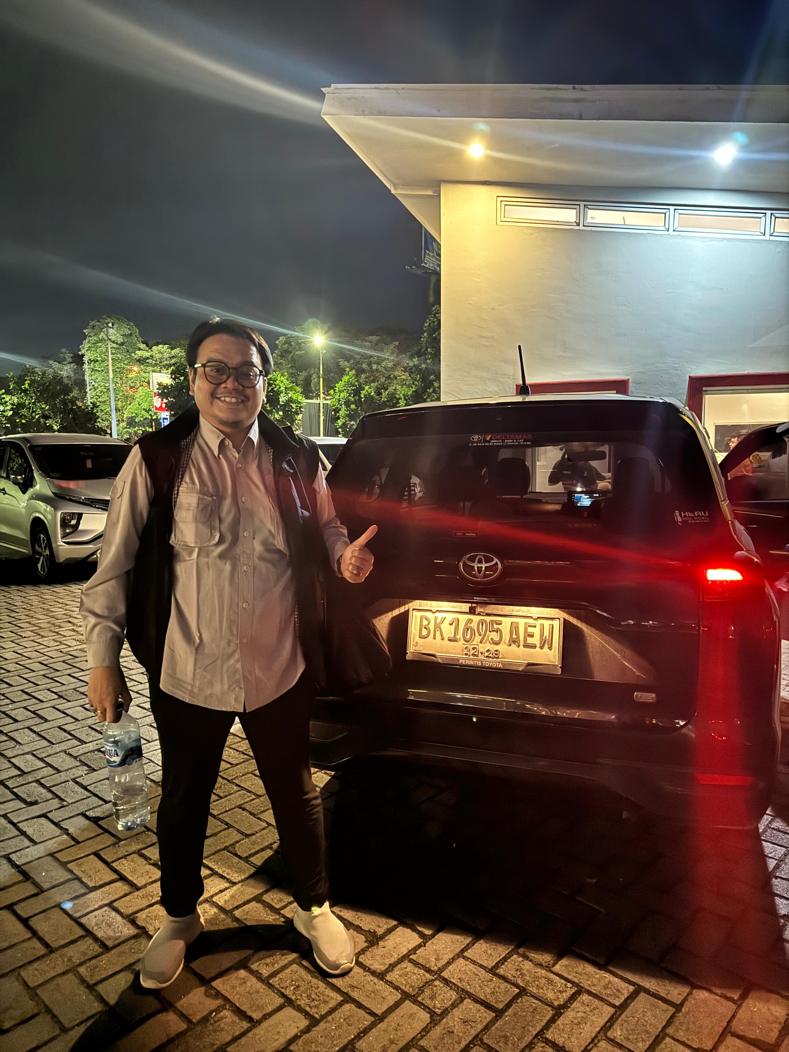 Pelanggan menerima kunci mobil dengan senyum puas